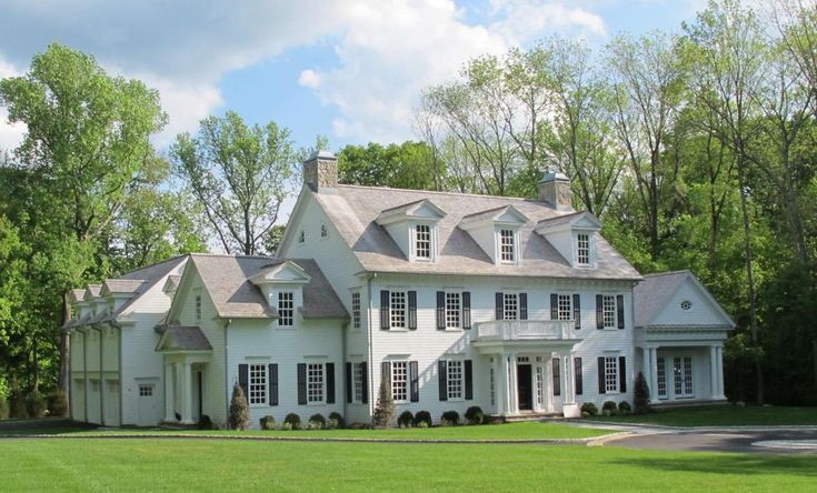 a large white house sitting on top of a lush green field