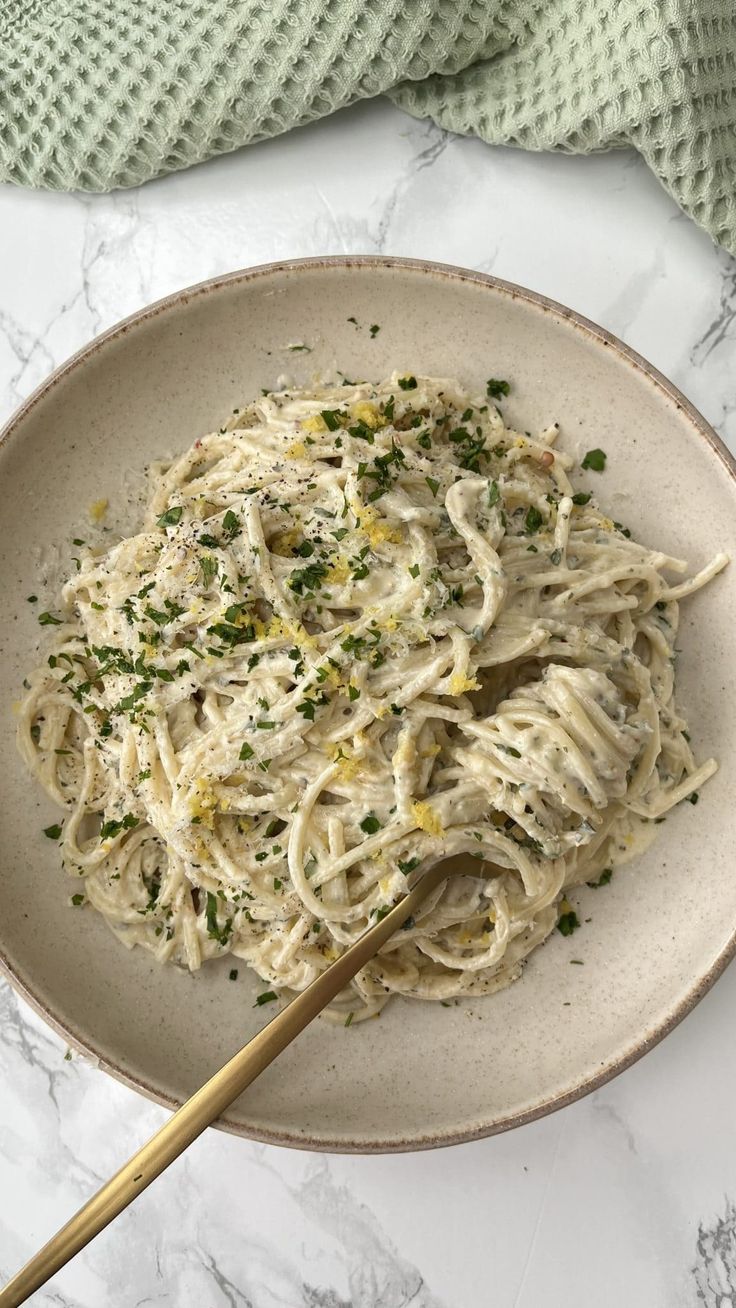 a white plate topped with pasta and parmesan cheese