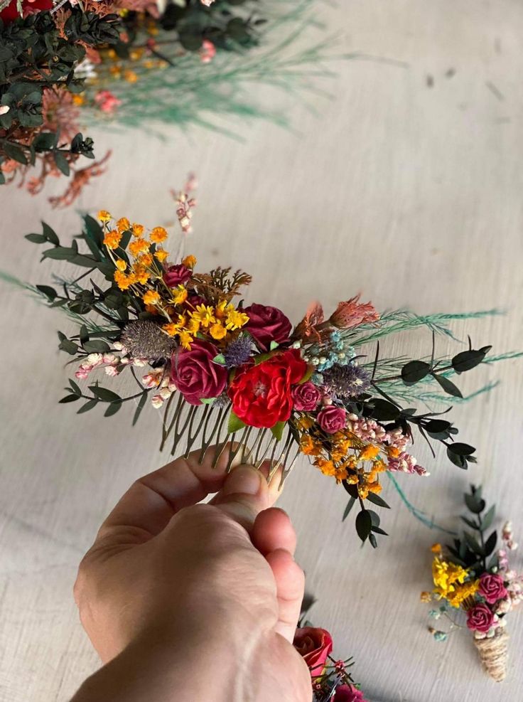 someone is arranging flowers on the table with their hair combs in front of them