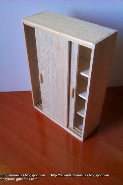 a small wooden cabinet sitting on top of a hard wood floor next to a wall