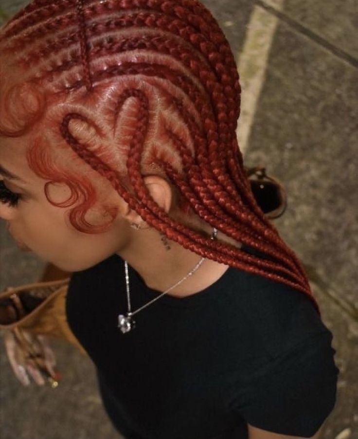 a woman with red braids on top of her head looking down at the ground