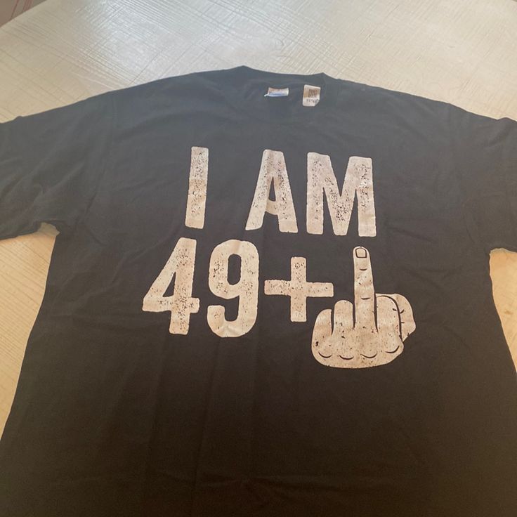 a black t - shirt with the words i am 94 on it is laying on a table