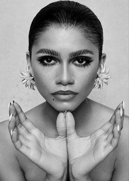 a black and white photo of a woman with flowers on her face, holding hands in front of her face