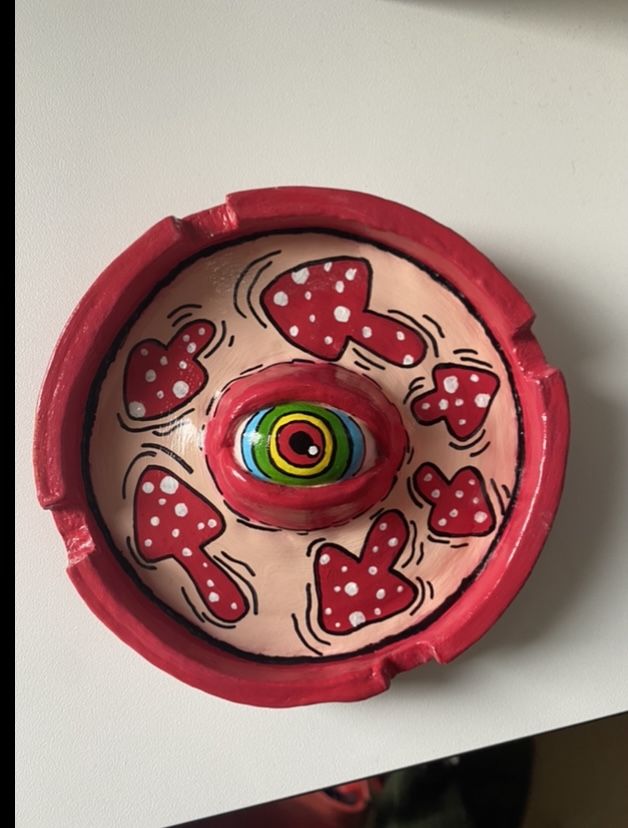 a red and white bowl with hearts on it sitting on a table next to a mirror