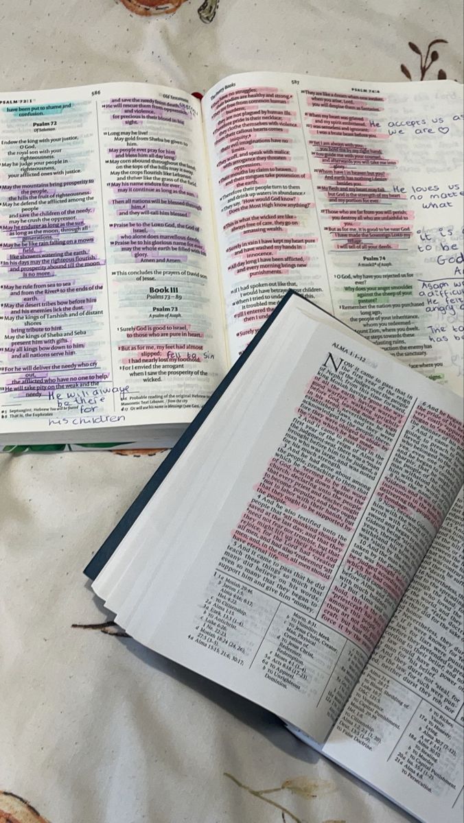 an open bible on a table next to some other books and papers that have been written in different languages