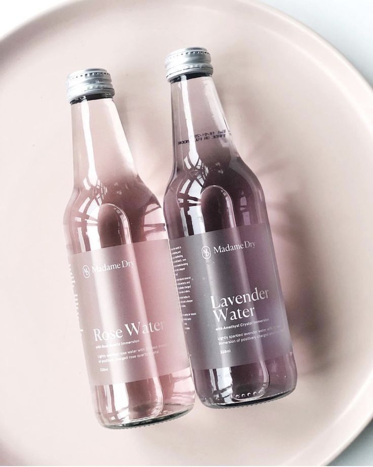 two bottles of water sitting on top of a white plate