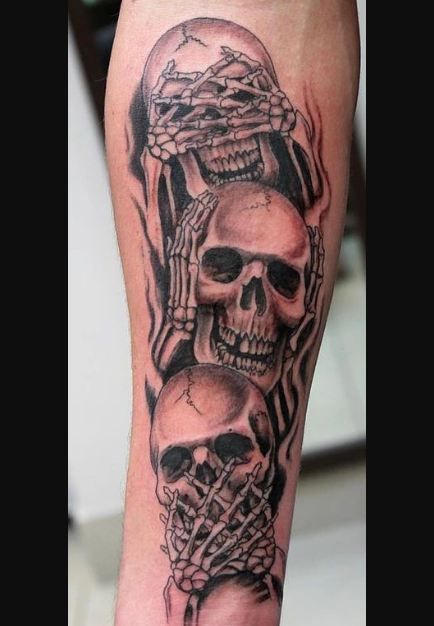 a man's arm with two skulls and a cross on the inside of it