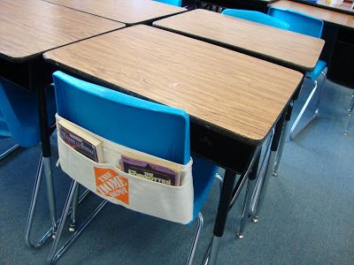 an empty classroom with blue chairs and desks