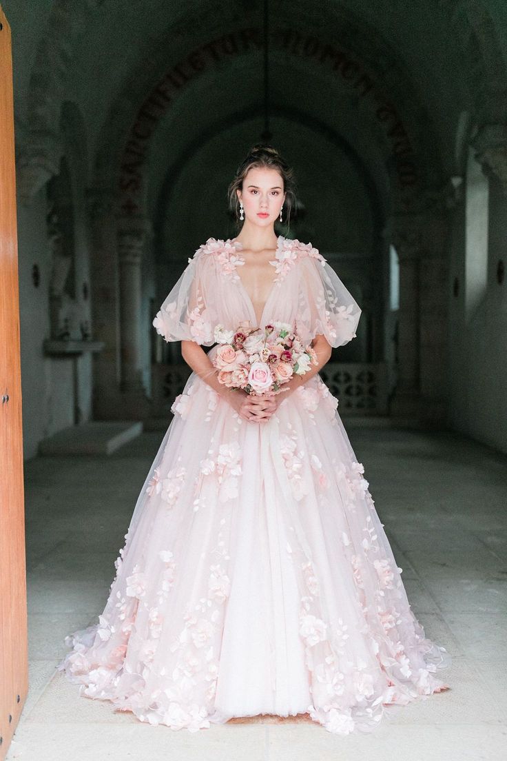 a woman in a pink wedding dress holding a bouquet