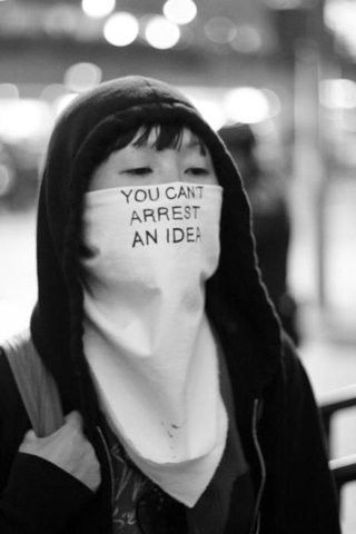 a person wearing a mask with the words you can't arrest an idea written on it