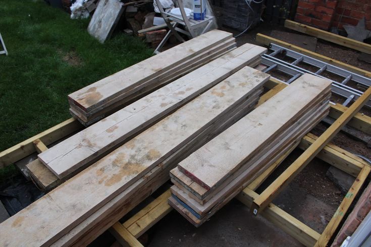 several pieces of wood sitting on top of each other in front of a brick building