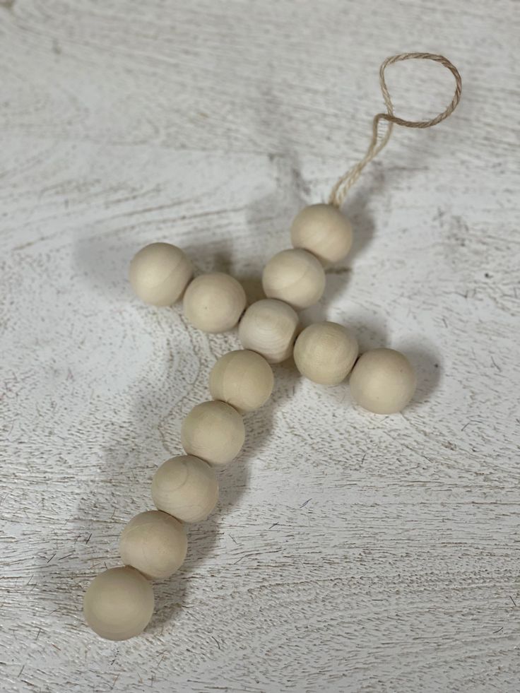 a cross made out of wooden beads on a table