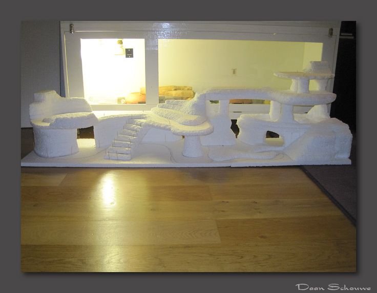 a cat bed made to look like a castle with snow on the roof and stairs