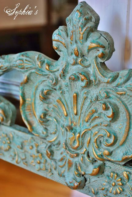 an ornate wooden frame with gold paint on the top and bottom, sitting on a table