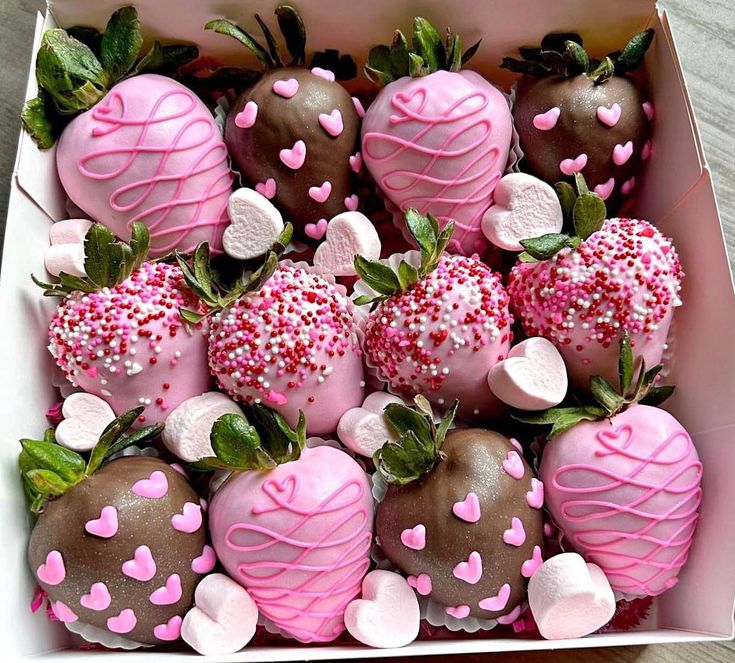 a box filled with lots of pink and chocolate covered strawberries