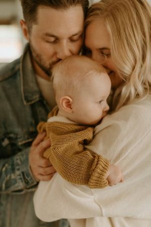 a man and woman holding a baby in their arms