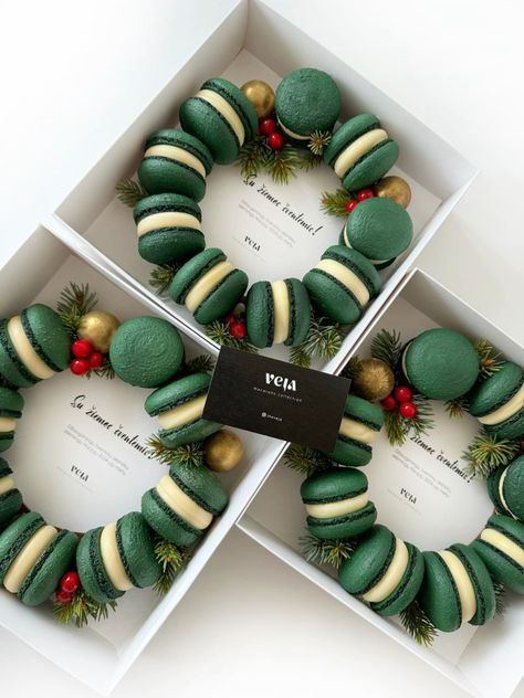 three boxes filled with green and gold decorated doughnuts in the shape of wreaths