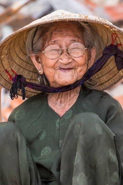 an old woman wearing a straw hat and green dress