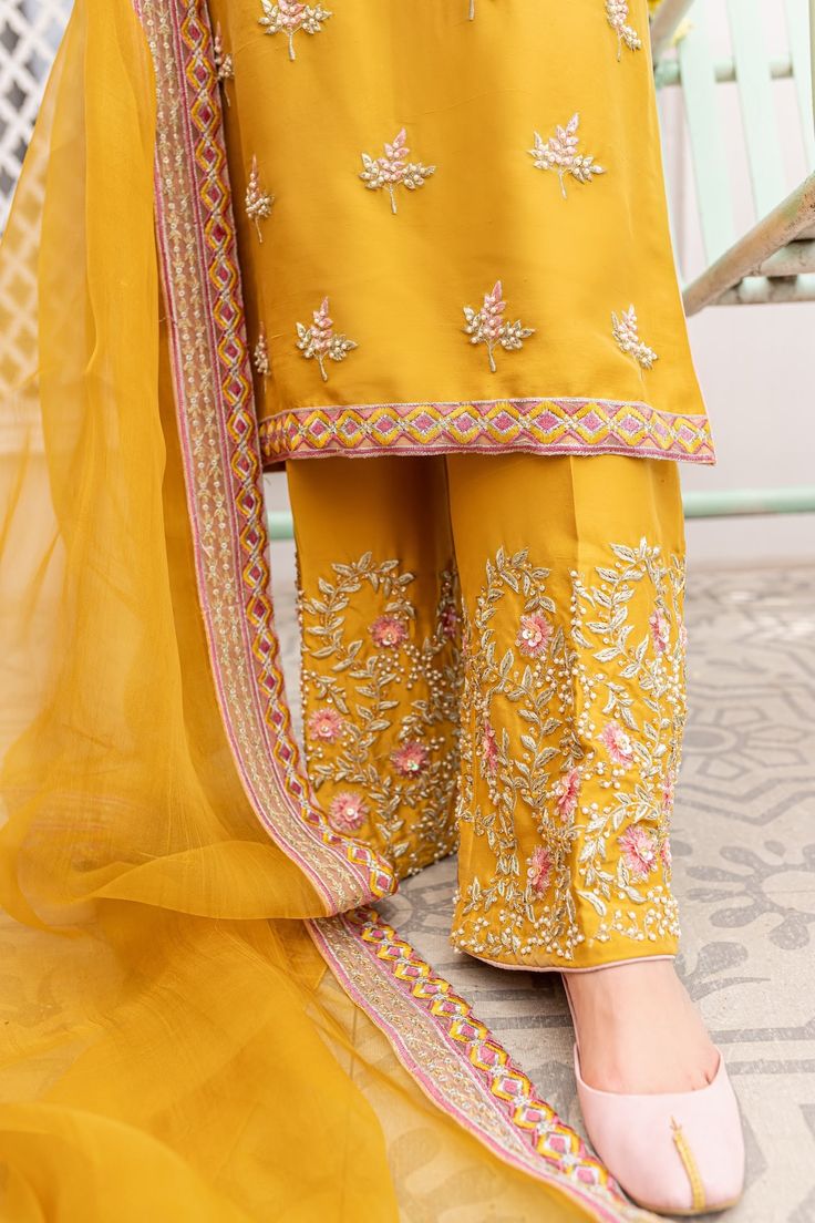 The elegant Pakistani Raw Silk Salwar Kameez Dupatta Dress is a traditional masterpiece to have a charismatic appearance on the big day. Embroidery, Resham, pearls, and sequins make this stunning Pakistani Salwar Kameez your foremost priority to have a breathtaking look. Kameez: The beautiful kameez in an alluring yellow mustard shade comes in premium raw silk fabric. The stunning kameez is emblazoned with graceful embroidery, Resham, and lavish designs. Hand-crafted embellishments of Swarovski Raw Silk Salwar, Mustard Yellow Outfit, Classy Couture, Punjabi Dress Design, Punjabi Suit Neck Designs, Suit Neck Designs, Dupatta Dress, Embroidery Suits Punjabi, Yellow Suit