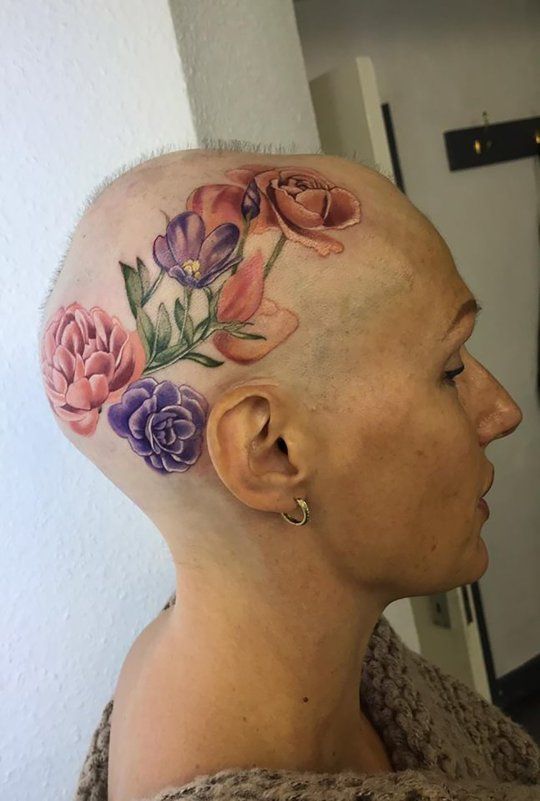 a woman's head with flowers on it, and the top part of her hair is shaved