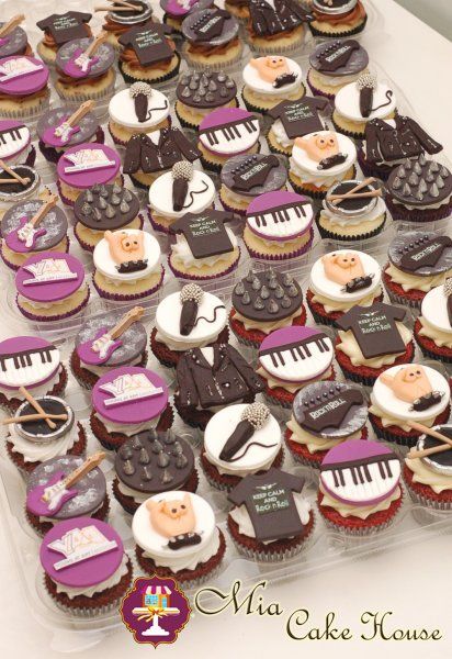 cupcakes are arranged in the shape of musical instruments and piano keys on display