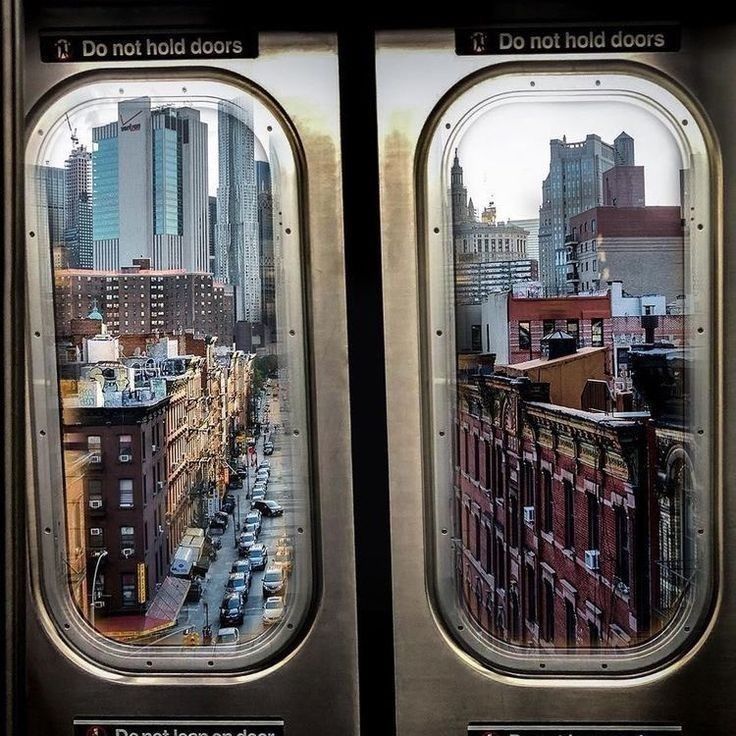 the view from inside an airplane window looking down on a cityscape with tall buildings