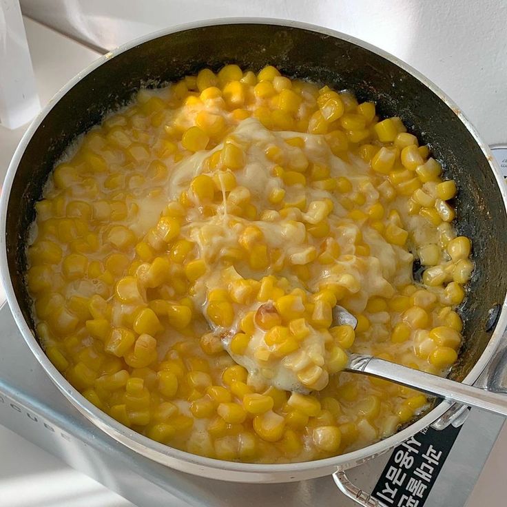 a pot filled with corn on top of a stove