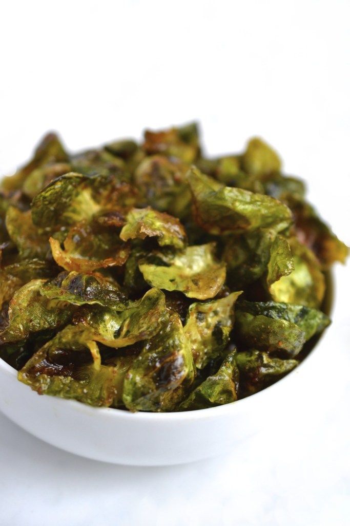 a white bowl filled with green vegetables on top of a table