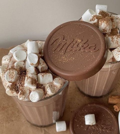 two cups filled with hot chocolate and marshmallows