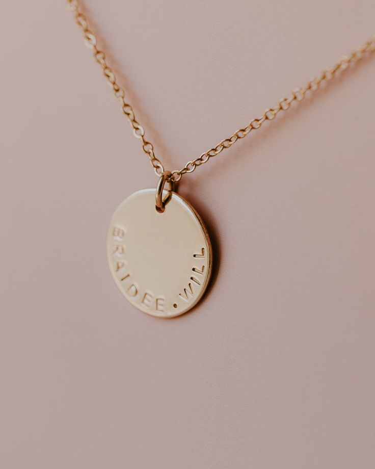 Name Disc Necklace The Name Disc Necklace is the perfect way to personalize your necklace with a special word or name that has meaning to you. With its smooth texture, your necklace will be stamped along the bottom edge of the disc. Disc measures at approximately a 1/2" in diameter. ***Max of 12 characters can be stamped on the disc. Please indicate your personalization in the box above. NOTE: Discs will be personalized exactly as indicated in the personalization box above.*** Made in 14k Gold F Meaningful Stamped Necklaces For Everyday, Adjustable Stamped Necklaces For Everyday, Adjustable Stamped Necklace For Everyday Wear, Everyday Meaningful Customizable Necklace, Everyday Stamped Round Disc Charm Necklaces, Everyday Stamped Round Disc Charm Necklace, Adjustable Stamped Necklace With Round Pendant, Simple Personalized Round Pendant Necklace, Minimalist Round Stamped Charm Necklace