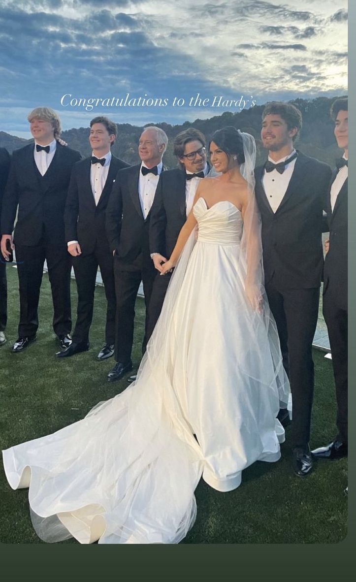 the bride and grooms are posing for a photo with their men in tuxedos