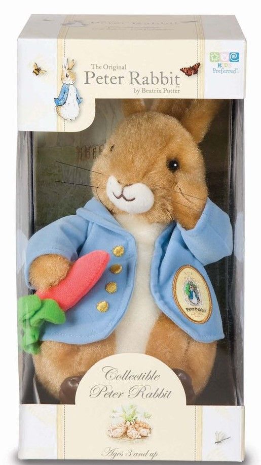 a stuffed rabbit in a box with a blue jacket on it's head and carrot