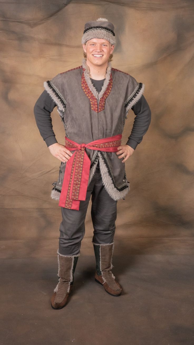 a man dressed in medieval clothing posing for the camera with his hands on his hips