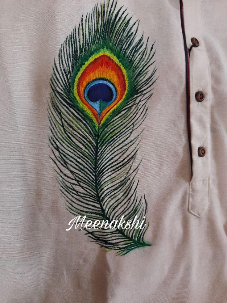 an embroidered peacock feather on a white shirt