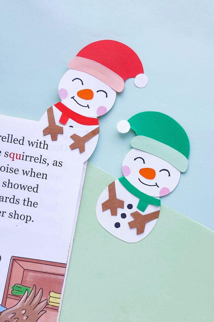 an open book with cut out snowmen on it