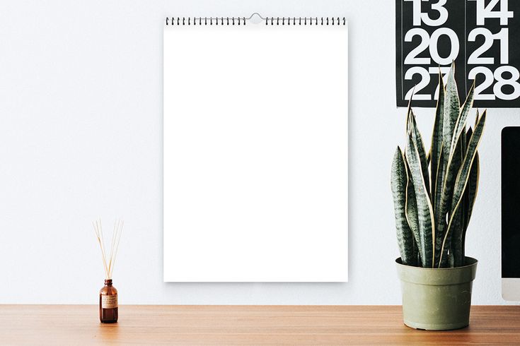 a desk with a plant and calendar on it