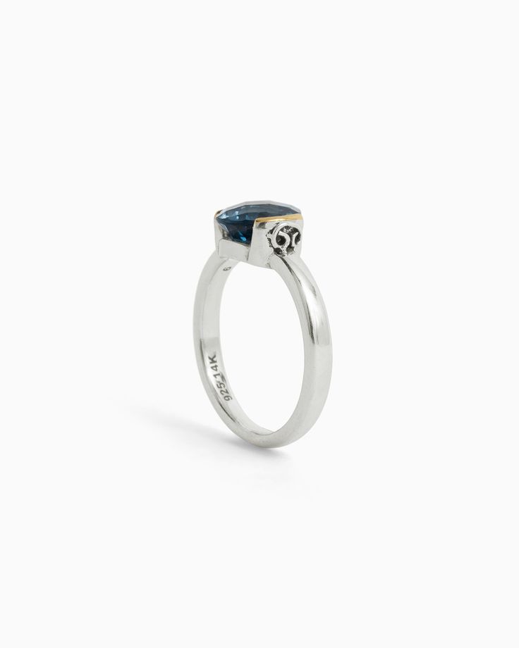 The Gemstone Ring is meticulously handcrafted in gently hammered sterling silver, adorned with a 14K gold half bezel that accentuates a stunning faceted London blue topaz stone. This unique design is elevated further by the presence of the iconic St. John petroglyph, intricately detailed on the side. Metal: Sterling silver with 14K gold accents Stone: London blue topaz Band Width: 3mm Stone Size: 8mm Style #: R217LB Fine Jewelry Blue Topaz Rings With Bezel Setting, Anniversary Blue Topaz Faceted Rings, Elegant Faceted Blue Topaz Rings, Sterling Silver Topaz Ring With Bezel Setting, Sterling Silver Yellow Gold Topaz Ring With Polished Finish, Formal Sterling Silver Topaz Ring With Bezel Setting, Blue Topaz Rings With Bezel Setting, Yellow Gold Topaz Ring In Sterling Silver, Yellow Gold Topaz Ring With Polished Sterling Silver