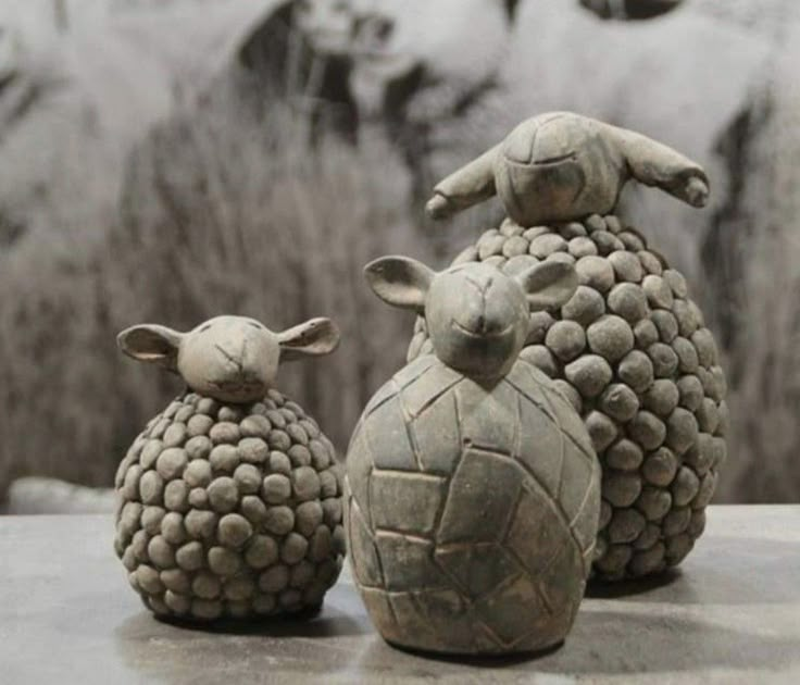 three ceramic sheep sitting next to each other on a table