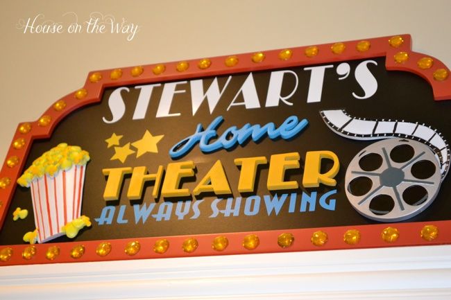 a sign that says stewart's home theater and is decorated with popcorn, film reels and stars