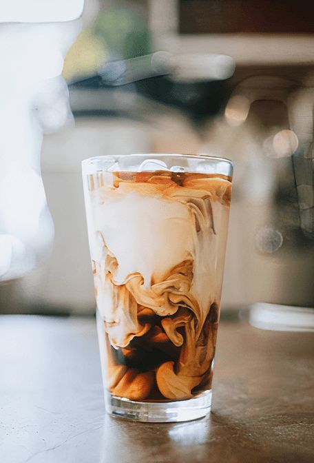 a glass filled with liquid sitting on top of a table