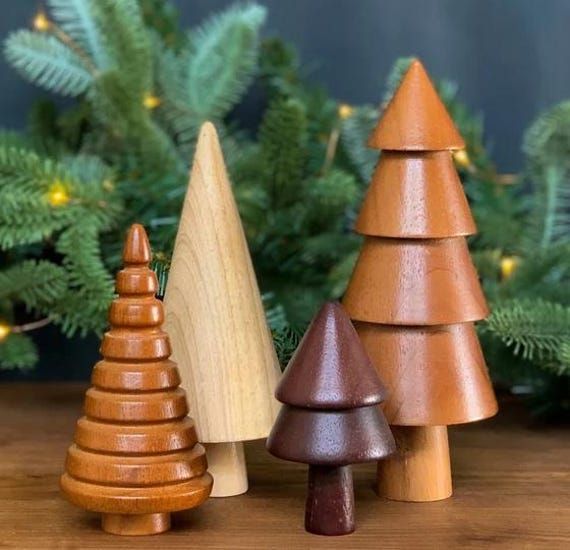 three wooden christmas trees sitting on top of a table