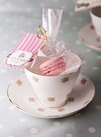 two teacups filled with different types of pastries