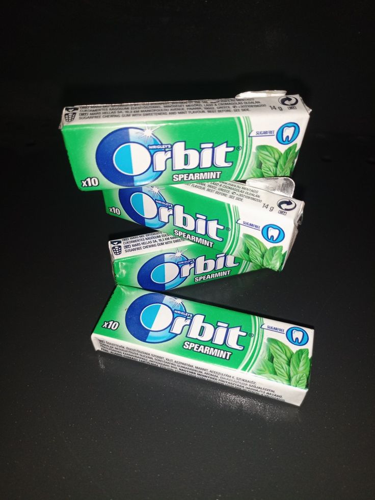 three tubes of toothpaste sitting on top of a black table next to each other