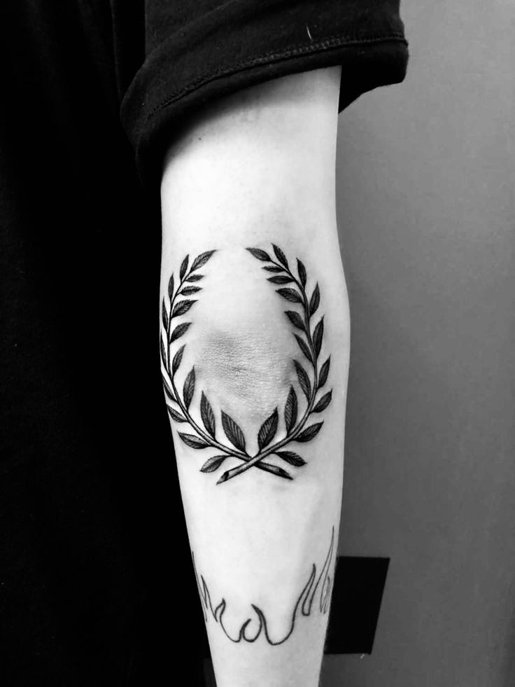 a black and white photo of a person with a tattoo on their arm