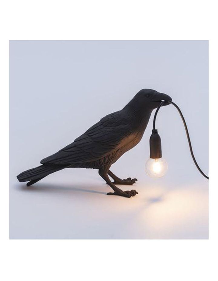 a black bird lamp with a light bulb attached to it's body, on a white background