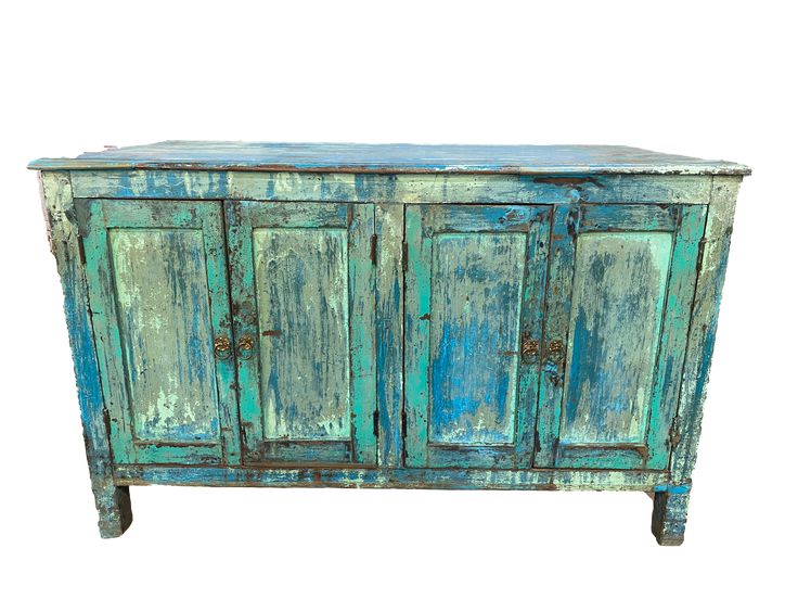 an old blue cabinet with peeling paint on the doors and drawers is isolated against a white background