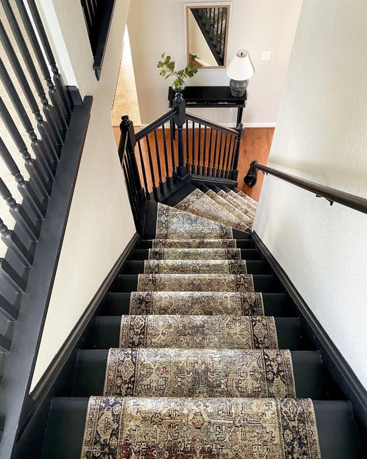 a stair case with rugs on the bottom