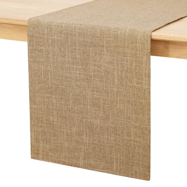 a close up of a table with a cloth on it and a wooden surface in the background