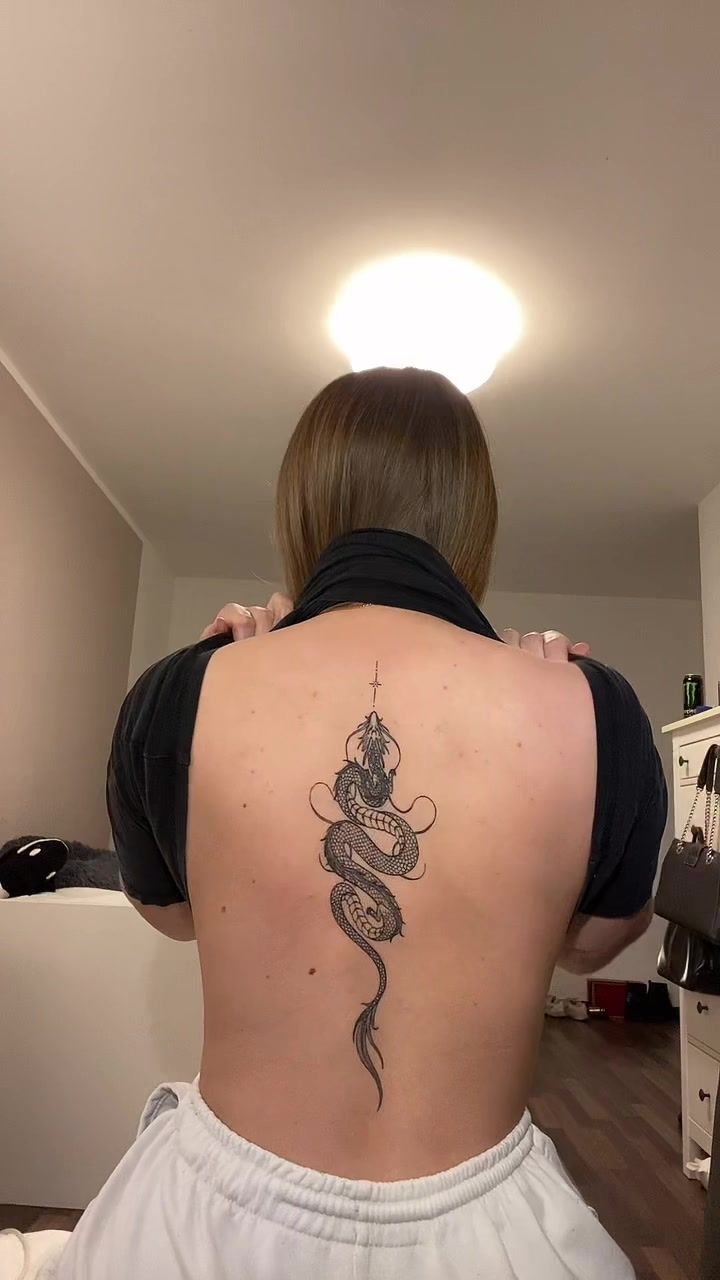 a woman with a snake tattoo on her back