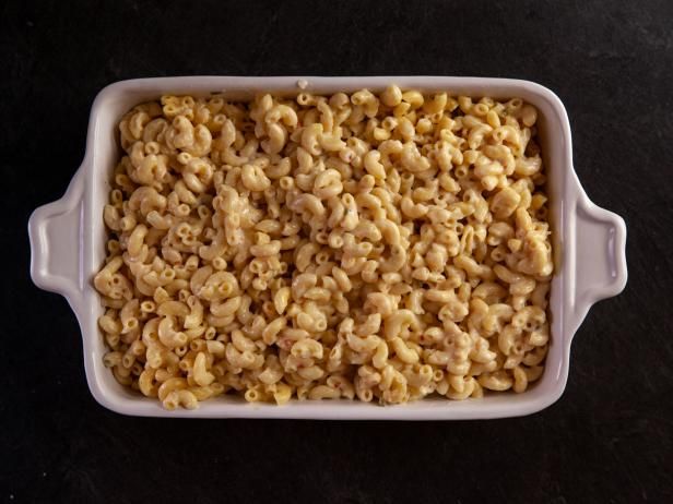 a dish filled with macaroni and cheese on top of a black countertop